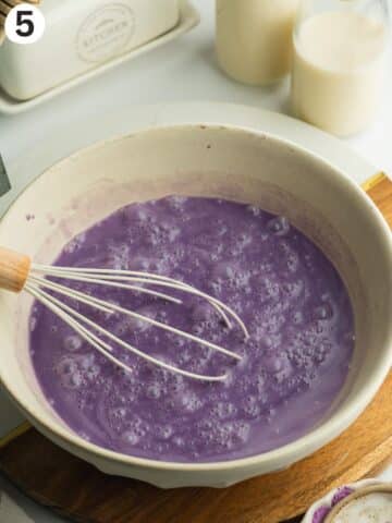 triple milk soak with ube condensed milk whisked in a ceramic bowl.