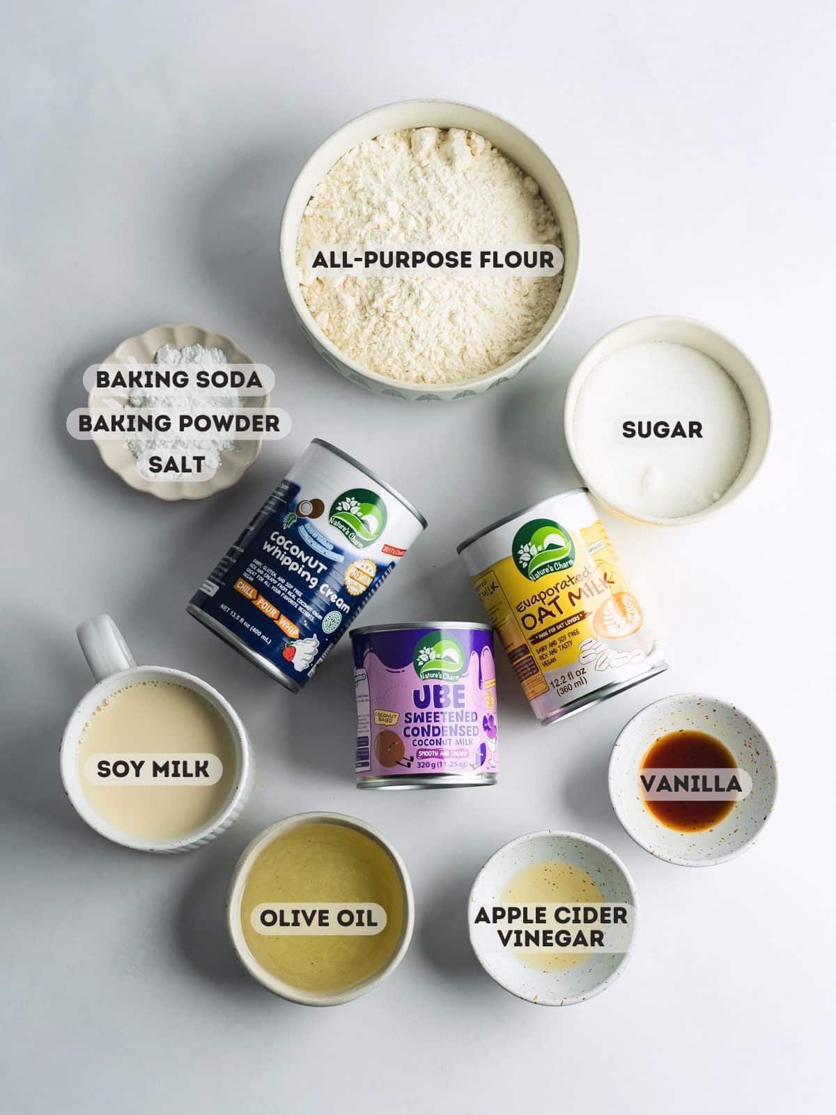 ingredients for ube tres leches measured in bowls on a grey surface.