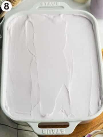 ube tres leches with ube whipped coconut cream spread on top.