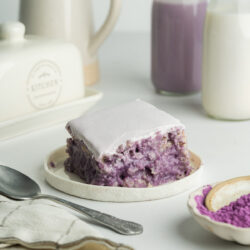 a slice of ube tres leches on a small white ceramic plate.
