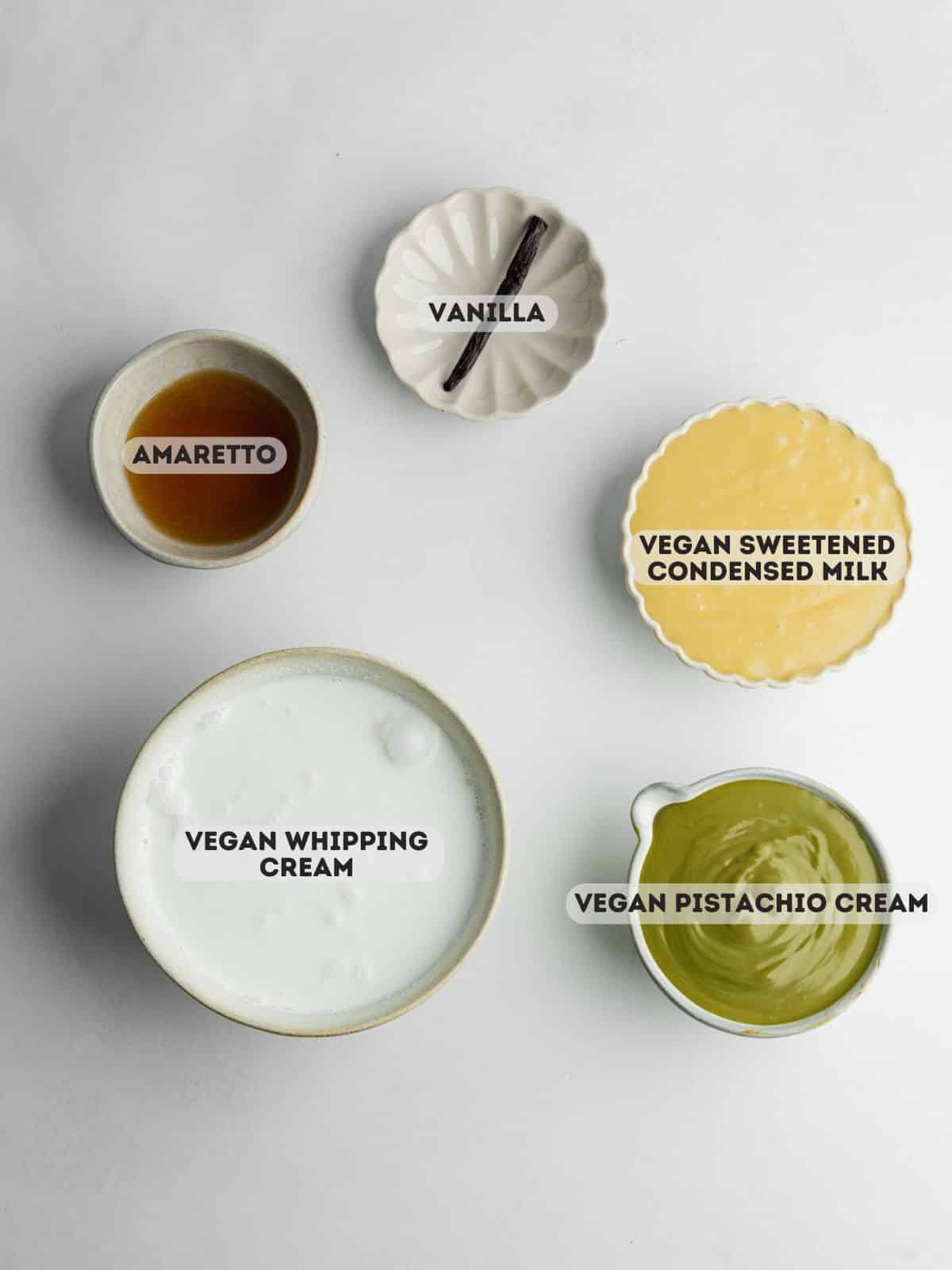 ingredients for pistachio ice cream measured in ceramic bowls.