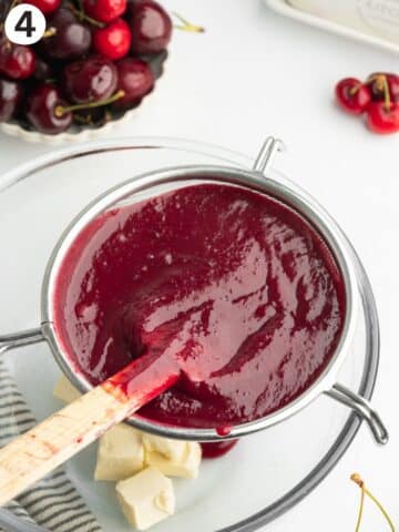 cherry curd in a sieve on top of a clear bowl with vegan butter in the bottom.