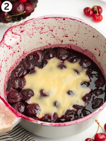 cooked cherries in a pan with vegan condensed milk.
