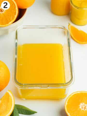 orange juice and cointreau mixed together in a shallow glass container.