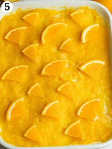tiramisu topped with orange curd and fresh orange segments.