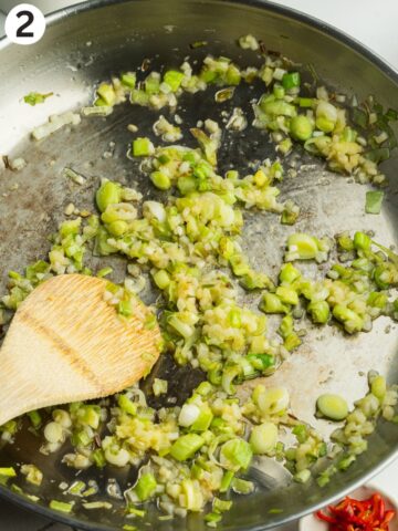 green onion, ginger, and garlic frying in a saucepan.
