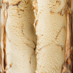 a closeup of espresso martini ice cream showing the creamy texture and fudge ripple sauce running through it.