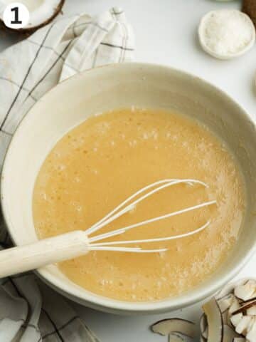 wet ingredients for coconut tres leches whisked in a bowl.