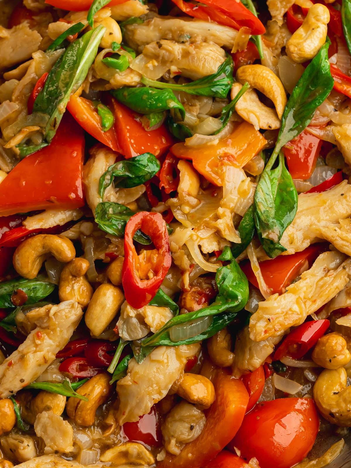 a closeup of thai basil veggie chicken with fresh vegetables in a pan.