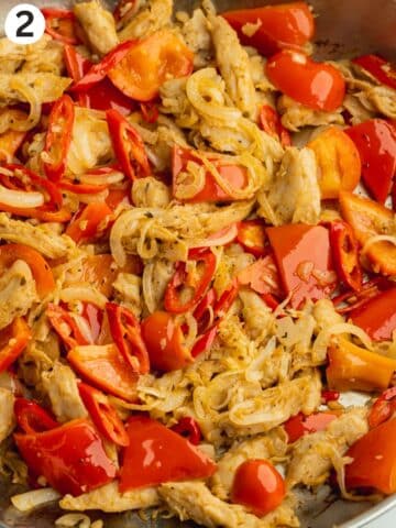 sauteed onion, garlic, chillis, and red bell pepper in a frying pan.