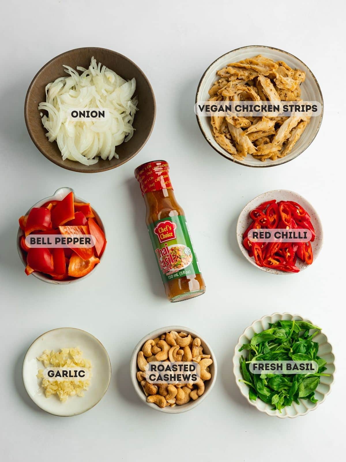 ingredients for thai basil vegan chicken measured out in bowls on a gray surface.