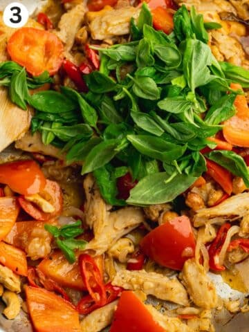 fresh basil added to stirfried veggies in a pan.