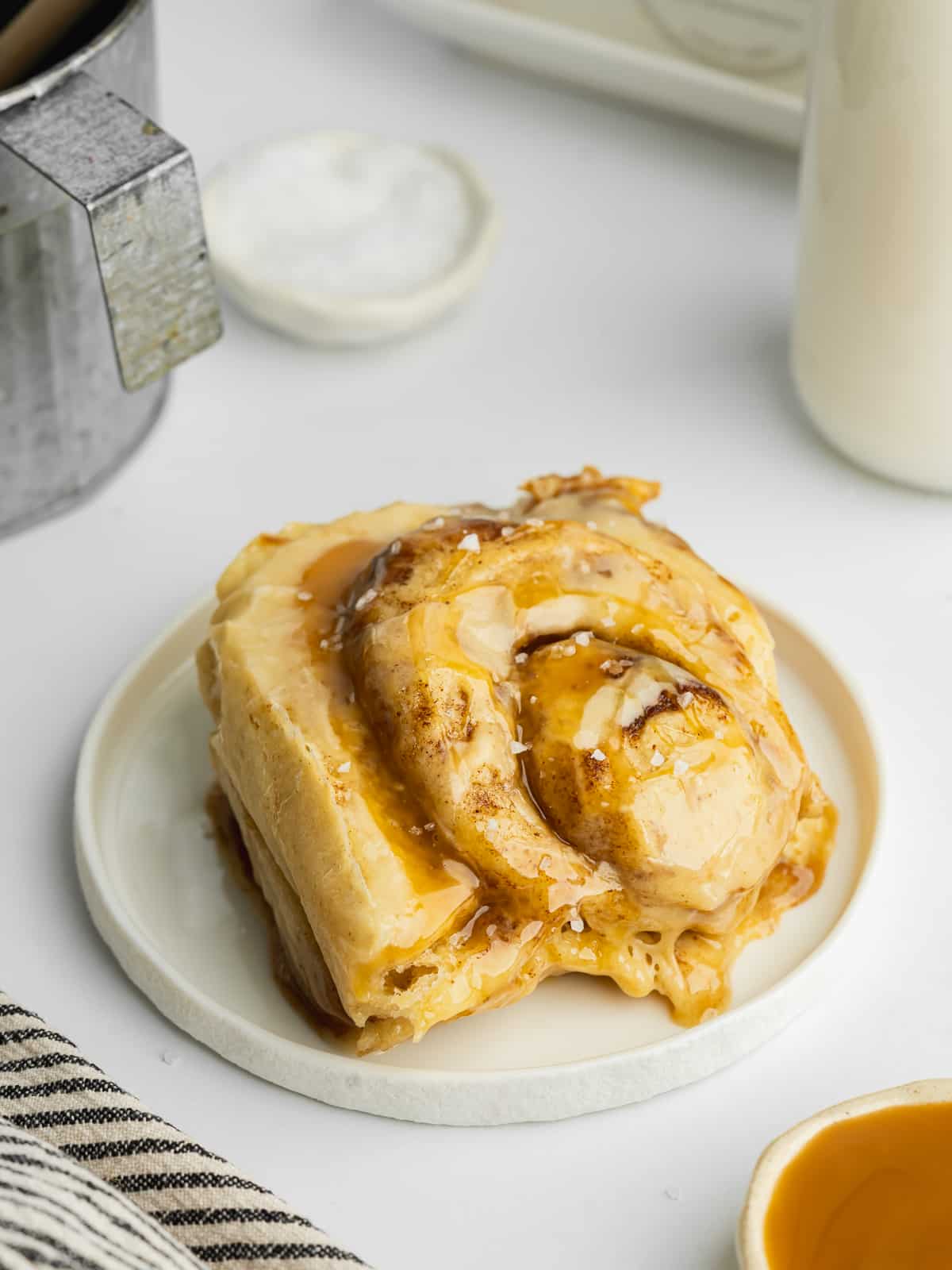a cinnamon roll filled with dulce de leche on a ceramic plate.