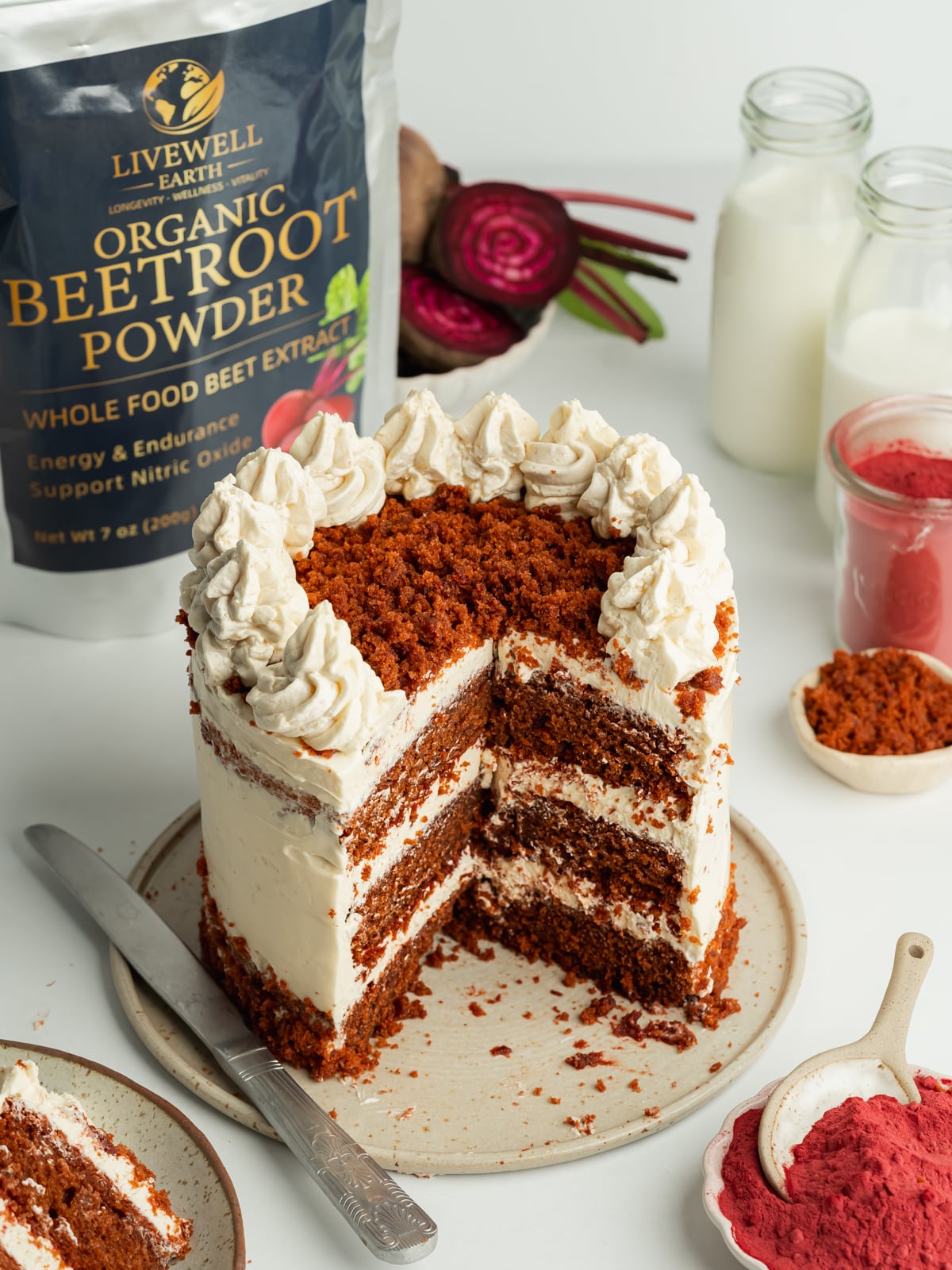 a red velvet layer cake topped with cake crumbs with a packet of beetroot powder in the background.