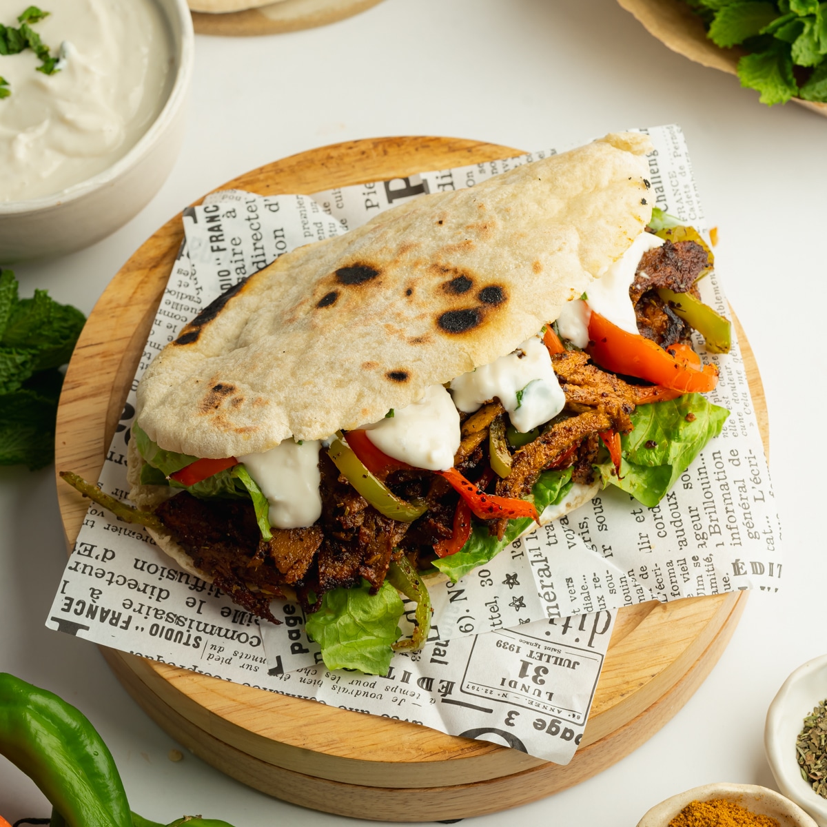 a toasted pita filled with marinaded setan shawarma, peppers, lettuce, and yogurt sauce.