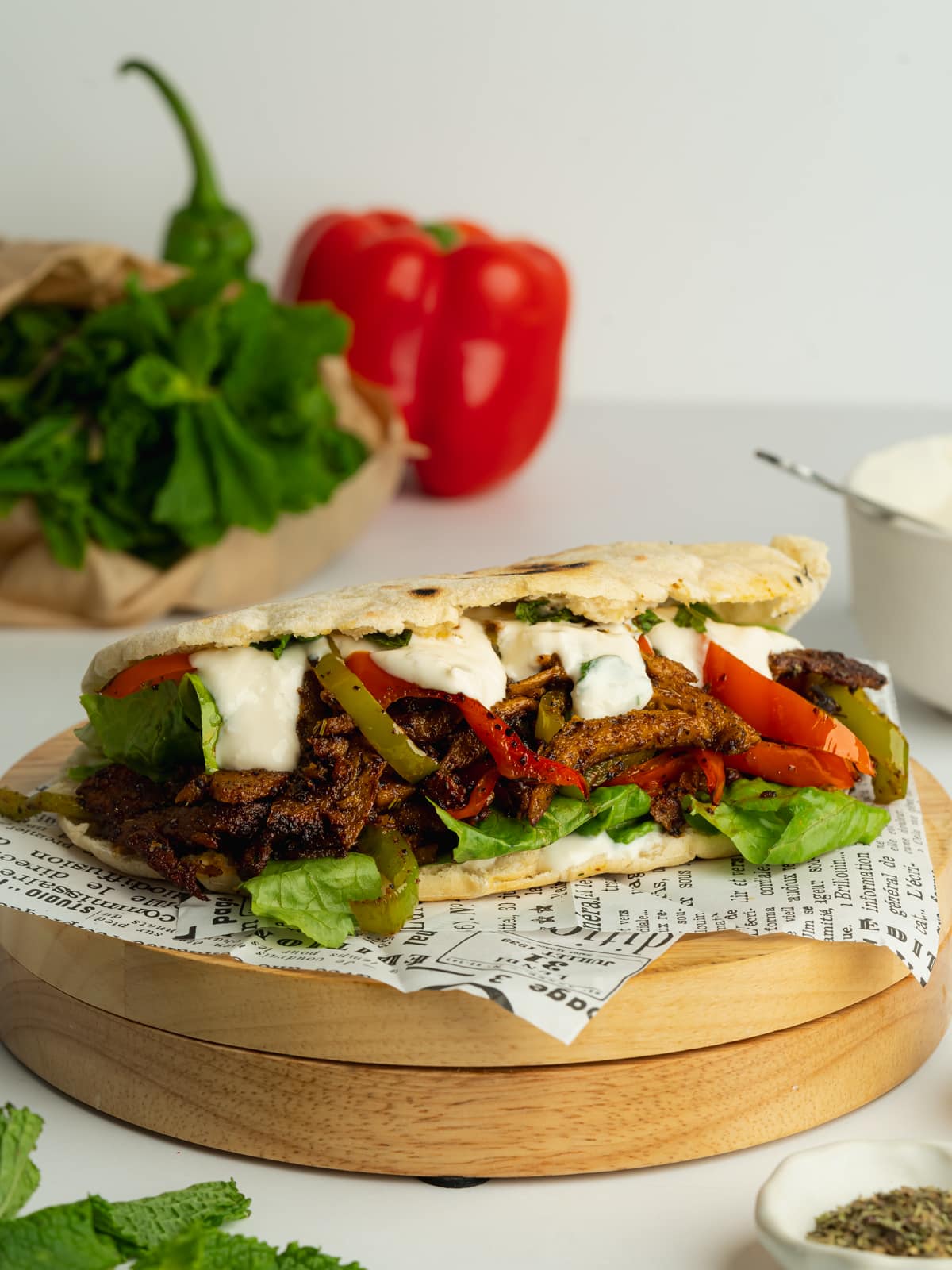 a vegan doner kebab with seitan on a wooden board filled with veggies.